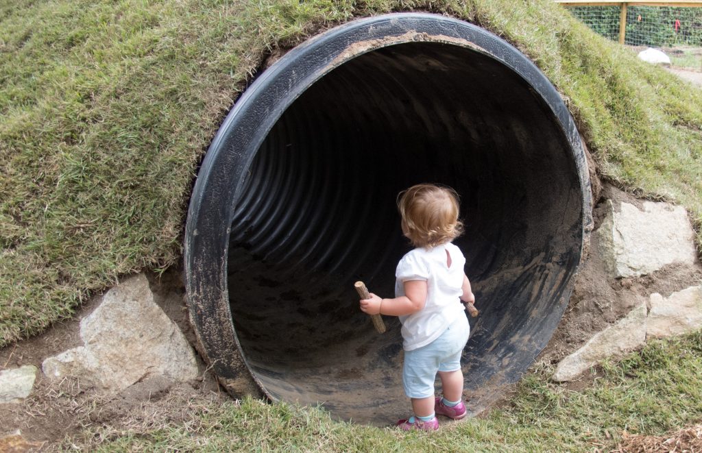 child looking into groundhog tunnel at Prairie Ridge