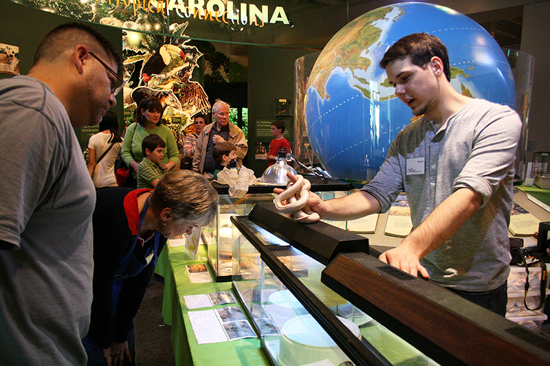 Volunteer at Reptile & Amphibian Day talking to visitors about snakes.