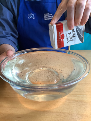 Sprinkling water surface with ground pepper.