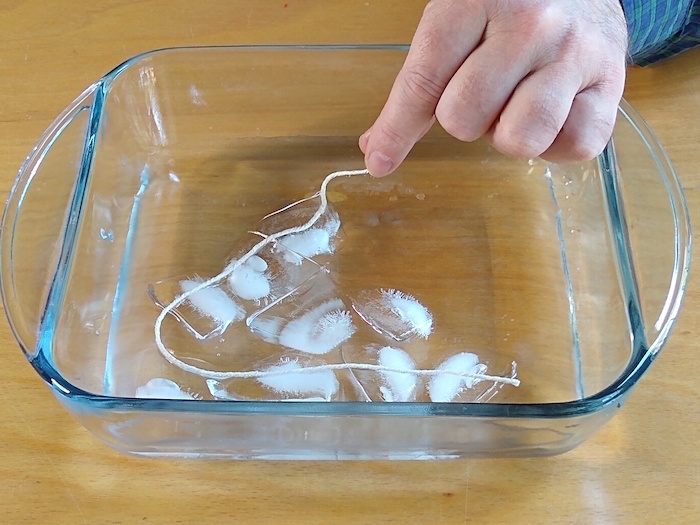 A string is laid onto an ice cube.