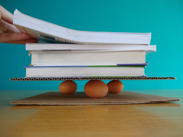 Books are being stacked onto the eggs. They aren't cracking!