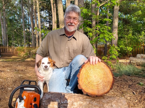 Bob Alderink poses with his dog and a tree with bright rings.
