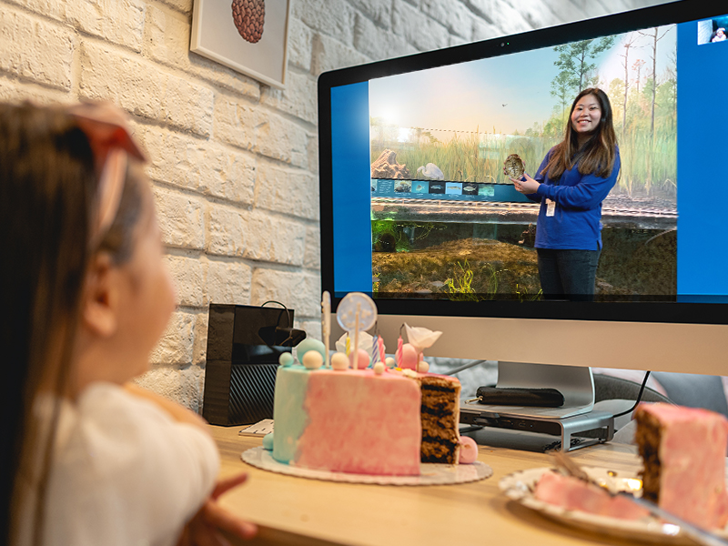 Museum educator leading birthday girl through an interactive educational presentation.