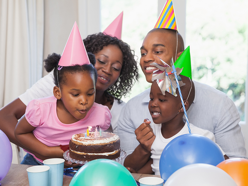 Family celebrating a birthday together at home in the kitchen