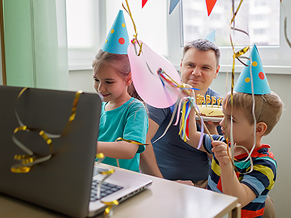Family birthday party around a laptop computer.