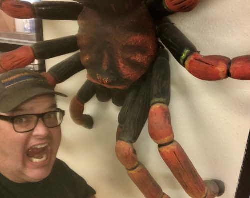 a man screaming at a giant fake spider