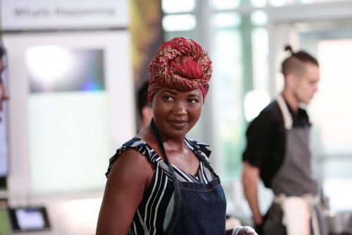 a woman with a red turban and apron preparing bug food