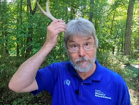 Bob Alderink putting a deer antler on his head.