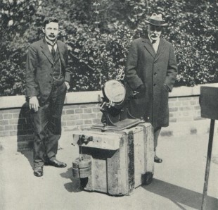 An old photo of two men by scientific equipment