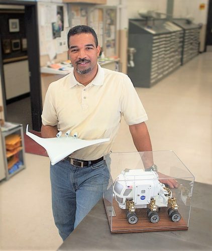A man standing with a NASA model