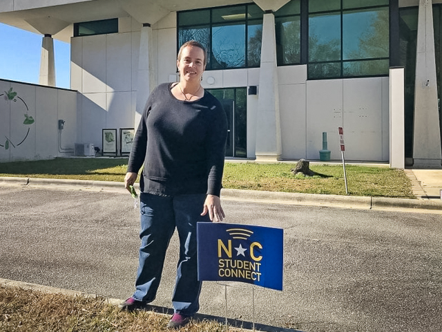 Dr. Shelby Gull Laird, head of the North Carolina Museum of Natural Sciences at Whiteville, stands next to a sign advertising free 24/7 WiFi available at the downtown facility.