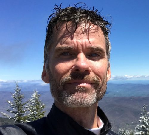 Dr. George Elvin's headshot with mountains in the background