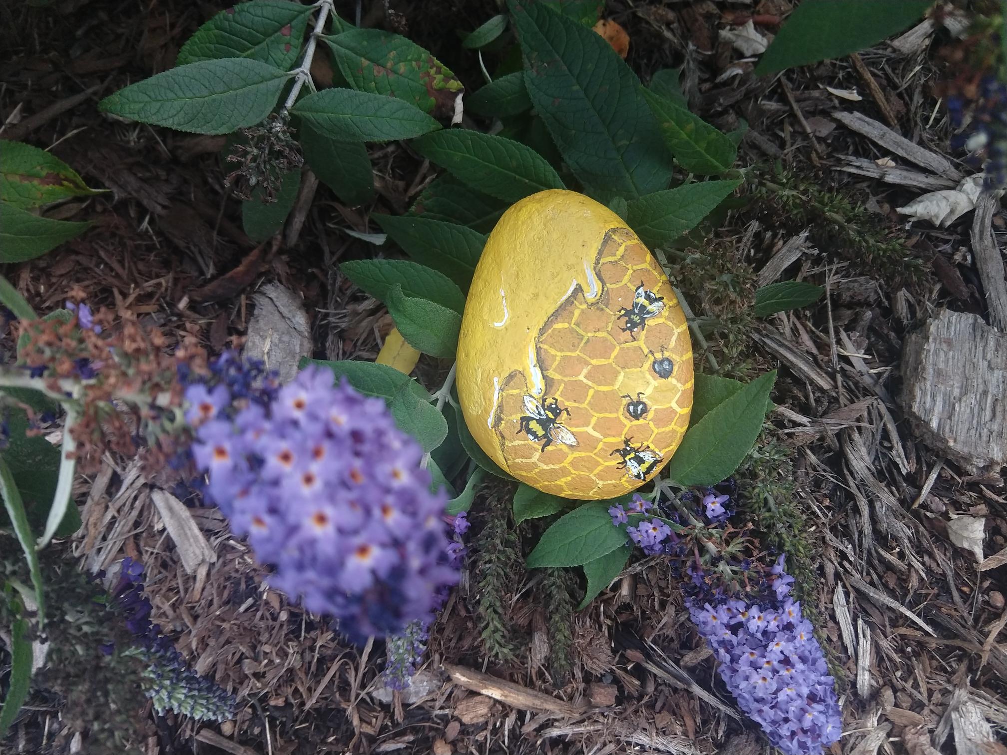 Yellow bees and honeycomb painted on a rock