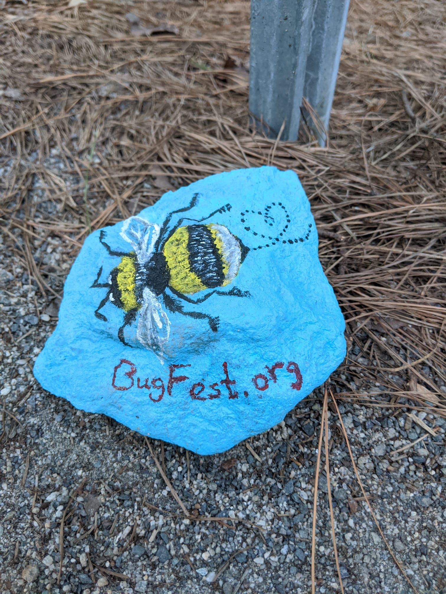 A bee painted on a rock with a blue background
