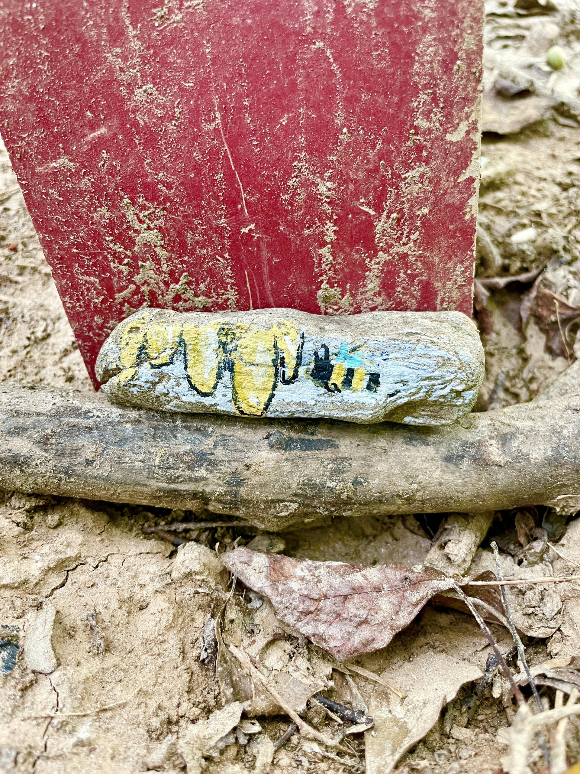 A bee and honey painted on a rock