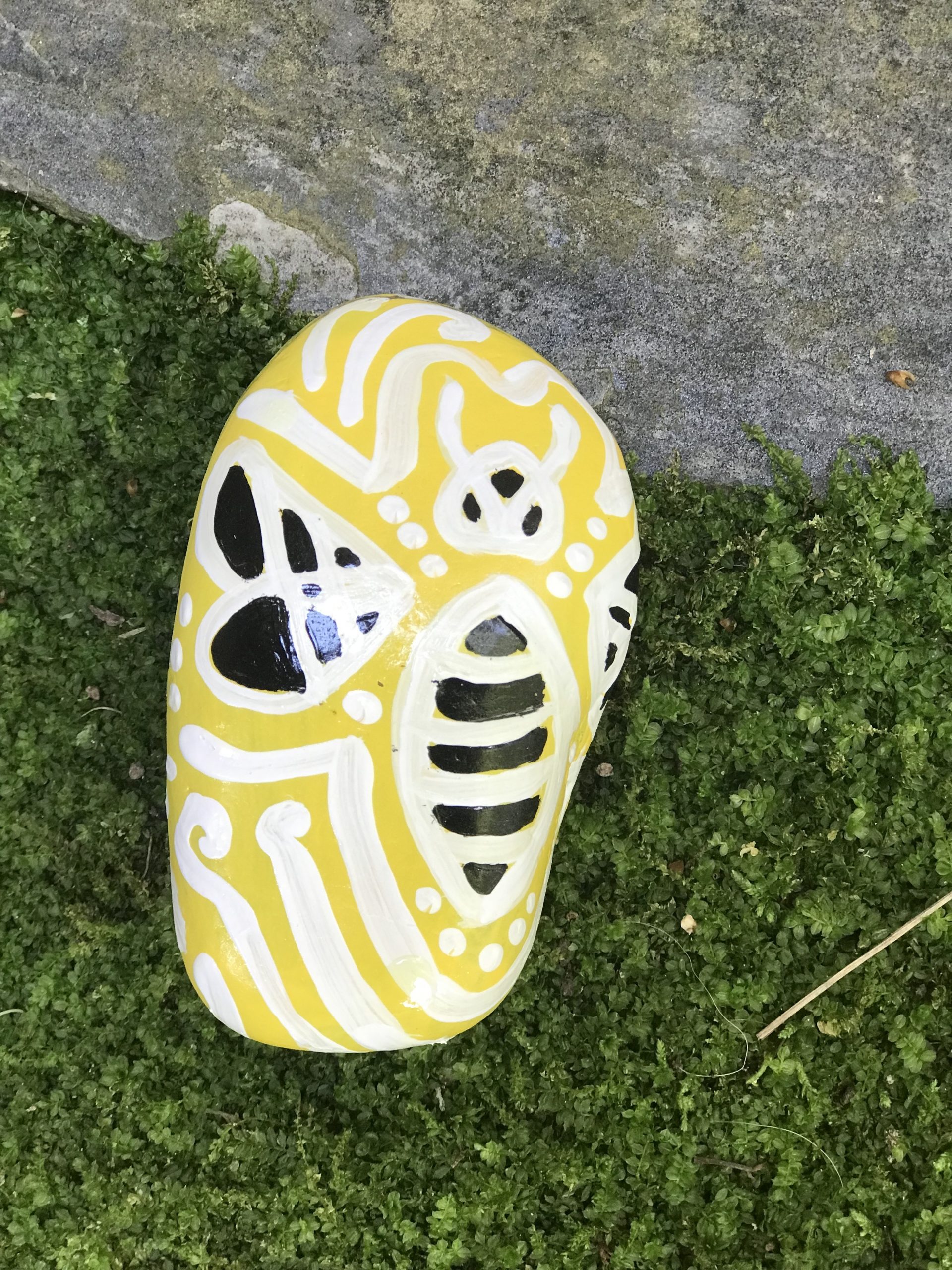 a stylized bee painted on a rock