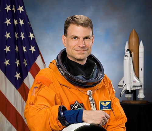 a male astronaut in an orange jumpsuit
