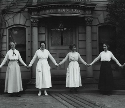 Women in long dresses holding hands