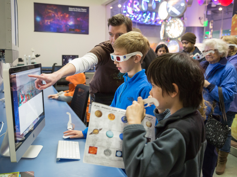 Guests in the Astronomy & Astrophysics Research Lab view 3D photos of Mars at Astronomy Days.