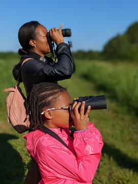 Mother and daughter birdwatching with binoculars. Photo: Michael Lewis/NCMNS.