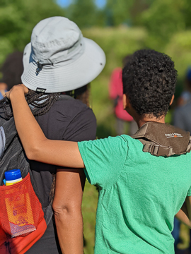 A mother and child survey the landscape of Prairie Ridge for birds. A focus of Black Birders Week is intergenerational learning. Photo: Michael Lewis/NCMNS.