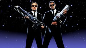 Will Smith and Tomy Lee Jones posing with guns over a sky with stars