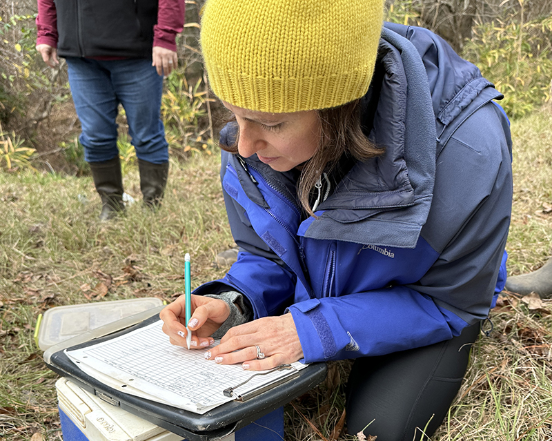 Woman recording data on a clipboard.