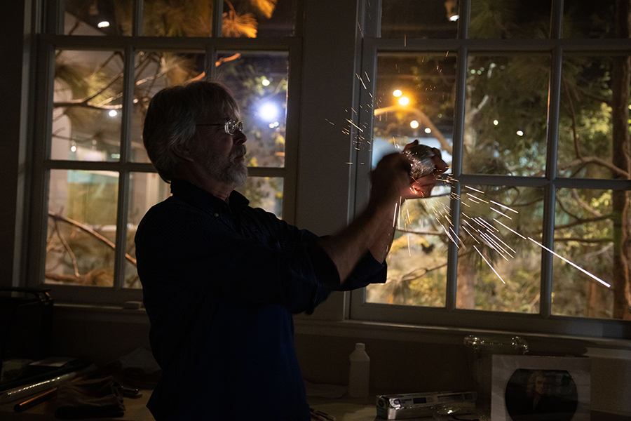 Bob Alderink, Head of Exhibit Hall Experiences, strikes two aluminum-covered objects together to generate sparks.