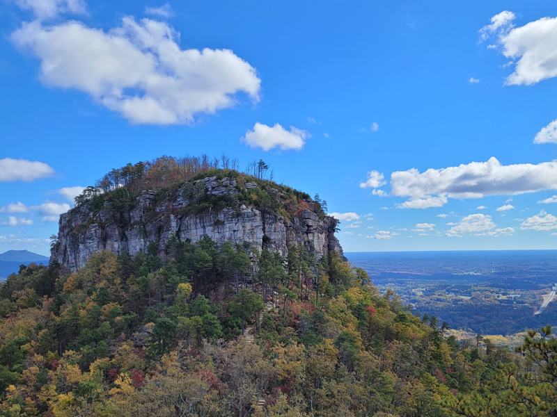 Blue sky and clouds over Pilot Mountain with fall foliage.