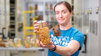 Still image from The Quest to Save Parasites: Woman holding jar of worm-like parasites