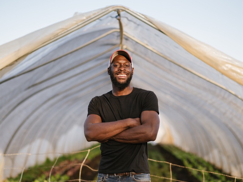 Kamal Bell: Owner, Sankofa Farms, with plant tent in background.