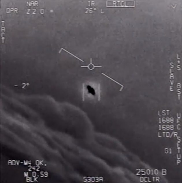 An unexplained object is seen at center as it flies among the clouds.