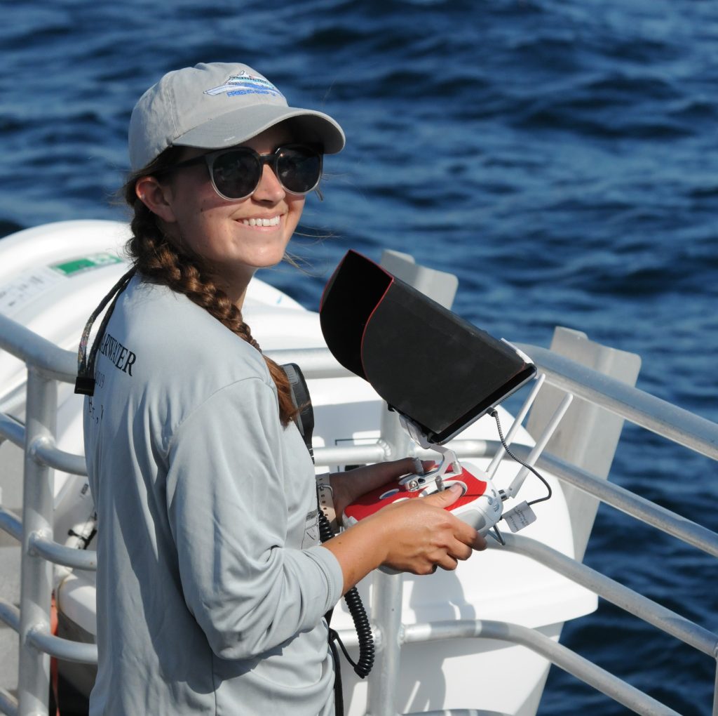 Photo of Anne Harshbarger on a boat holding a large remote control and smiling
