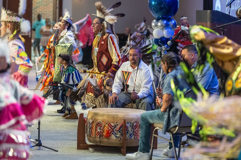 Members of the Waccamaw Siouan, adorned in regalia, play drums and dance in a cultural demonstration