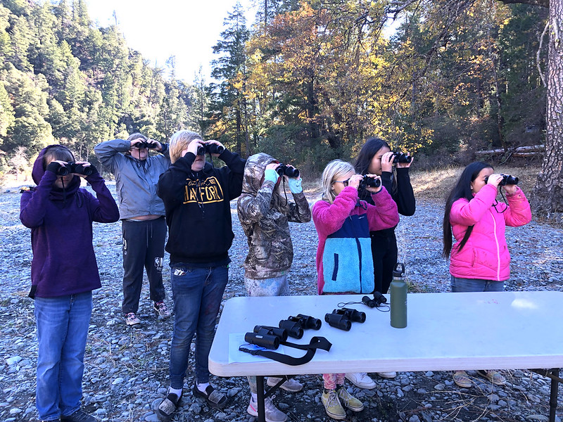 A group of students looks through binoculars