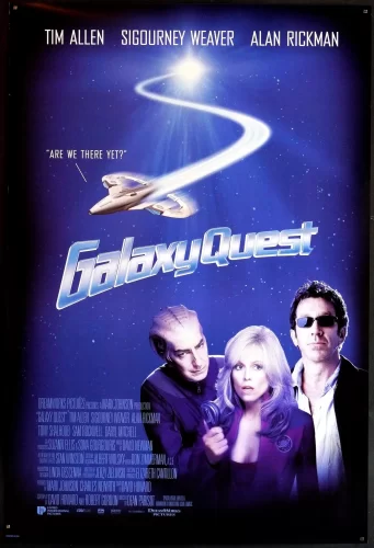 "Movie poster for \"Galaxy Quest\" featuring the three main characters striking heroic poses in front of a starry space background. A spaceship zooms past behind them, and the movie title appears in bold metallic letters in the middle of the poster."