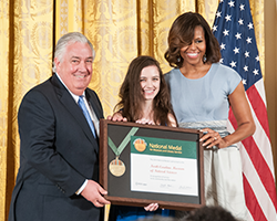 Museum Director Emlyn Koster and a Museum volunteer accept the National Medal for Museum and Library Service on behalf of the Museum from First Lady Michelle Obama.