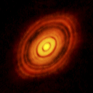 The sharpest image ever taken of a protoplanetary disk, the gas and dust surrounding forming stars (here, HL Tau, taken by the ALMA telescope). Dr. Smith has studied high-resolution spectra of this disk as part of her research [Smith et al., 2009, 2015] (Image Credit: ALMA (ESO/NAOJ/NRAO)).